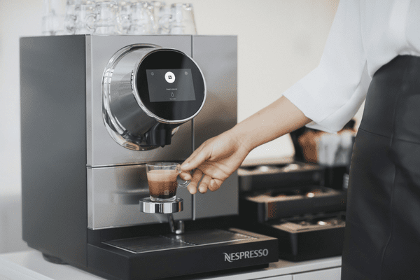 A white woman using the Nespresso Momento 100